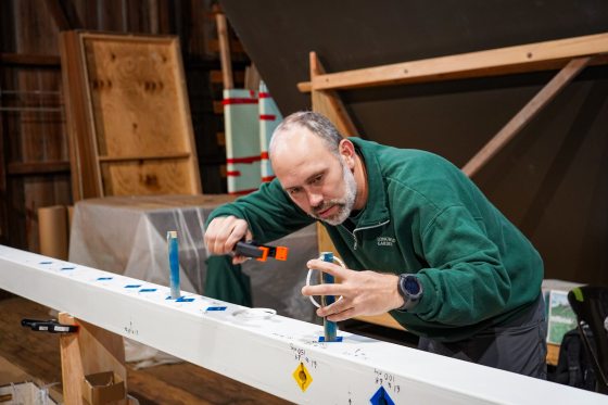 A person using a clamp overtop a white bar. 